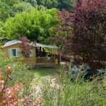 Een houten chalet tussen de bomen, te huur op de camping in de Dordogne