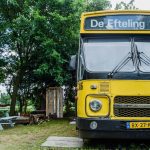 Een oude gele bus met als bestemming de Efteling, nu te reserveren als accommodatie op Camping BuitenLand