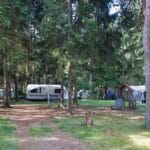 Caravan met luifel en een speelplaats in het Drentse bos