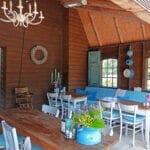 De gezamenlijke ruimte met twee tafels en blauwe stoelen op Camping Welgelegen
