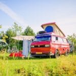 Volkswagen camper met luifel op een kampeerplek in Flevoland