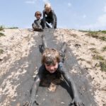Drie kinderen die samen aan het spelen zijn in de modder
