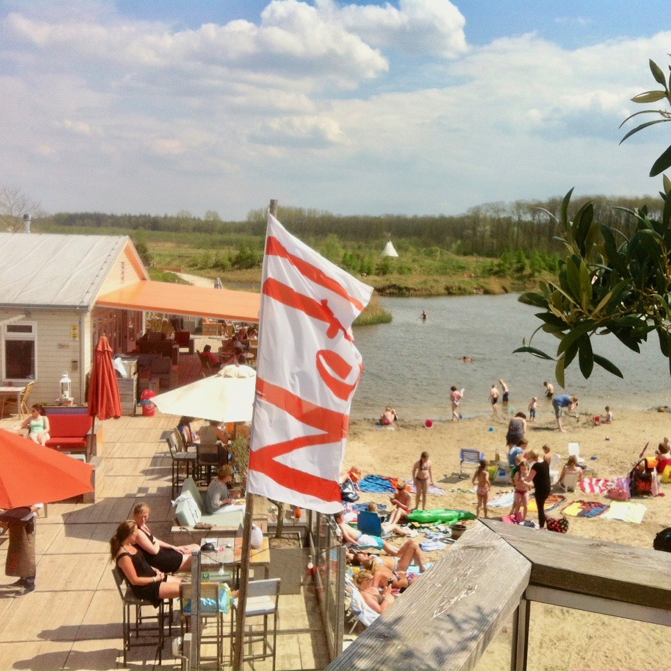 Een strandpaviljoen met gasten en zwemmende gasten
