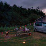 Camper met een picknicktafel en een vuurkorf op een natuurkampeerterrein in Brabant