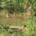 Kinderen en volwassenen aan het zwemmen in een meer in Noord-Brabant