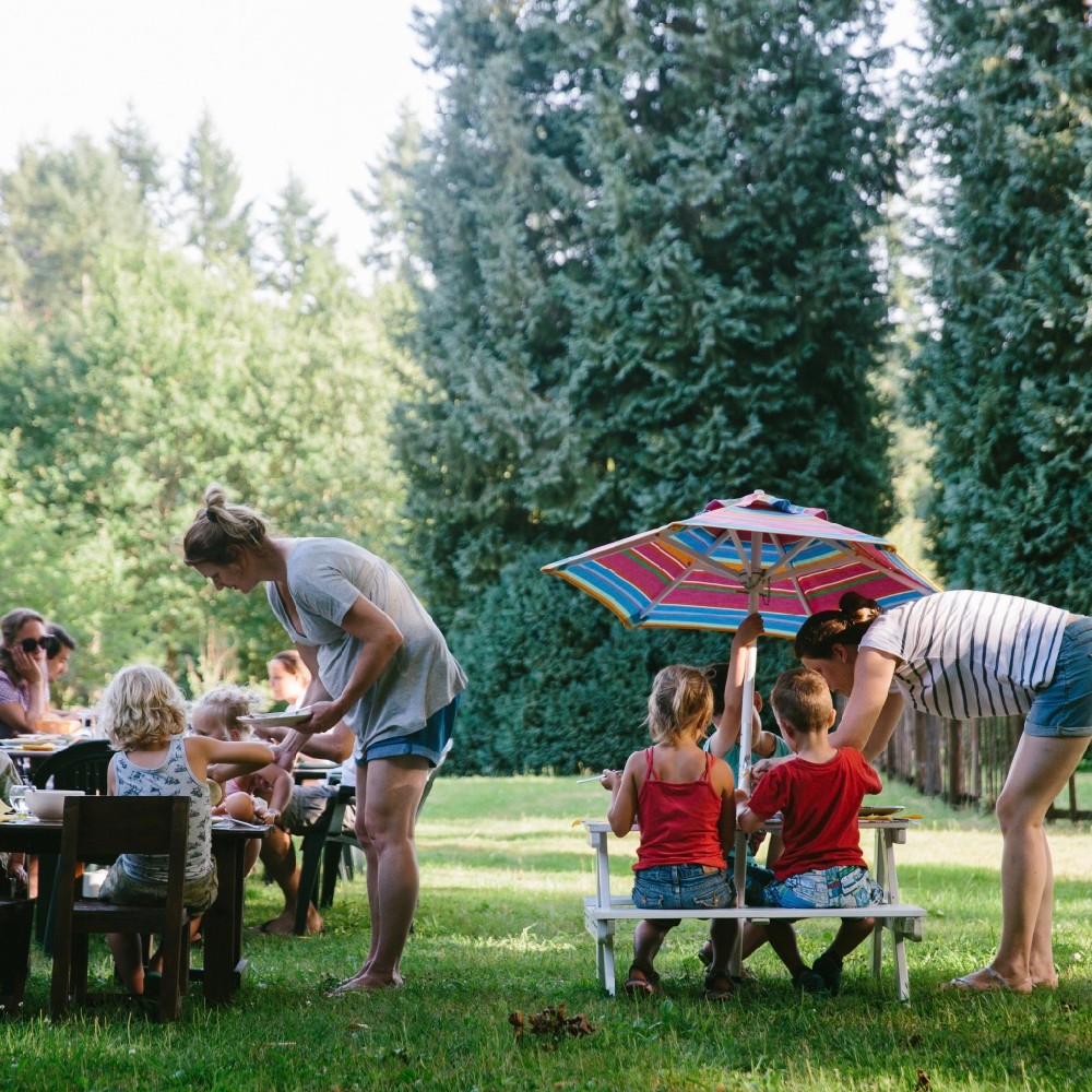kleine kinderen aan twee picknicktafels in het gras in Limousin