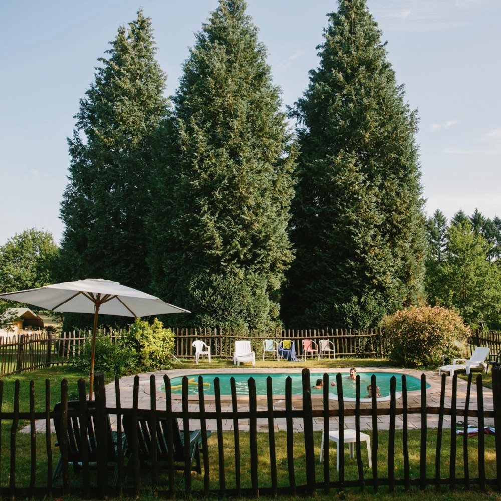Een zwembad omheind met een houten hek op een familiecamping in Frankrijk