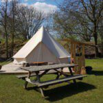 Bell tent met een picknicktafel ervoor op camping Leijland in Brabant