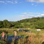 Een trampoline met springende kinderen en tenten in het veld