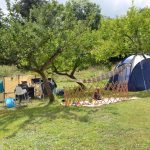Kindvriendelijke camping met slechts enkele kampeerplekken, een tent met een kindje ervoor