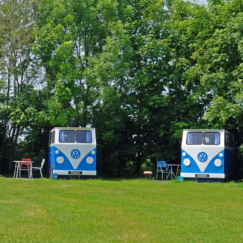 Twee houten volkswagen busjes op het kampeerveld