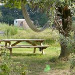 Picknicktafel met hangmat erboven op Natuurcamping de Joxhorst