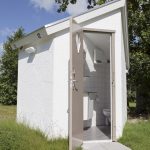 Een inkijkje in een sanitairhuisje, met hierin toilet en douche op camping Strand49