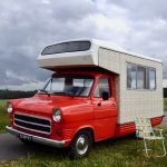 Een oude Ford camper, rood met wit