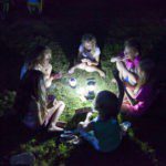 Kinderen rond een lamp op een kindvriendelijke camping in de Franse Dordogne