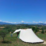 Tent op een kampeerplaats uitkijkend over de Italiaanse regio Le Marche