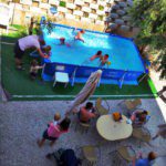 Klein zwembad met spelende kinderen en ouders eromheen op een kindvriendelijke camping in Italië