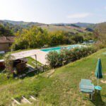 Zwembad met op de achtergrond groene heuvels in het oosten van Italië