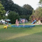 Kinderen op een trampoline op een speelveld op een kindvriendelijke camping in Limburg