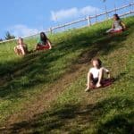 Vier kinderen aan het sleeën van een heuvel in Slovenië