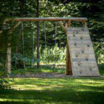 Twee schommels en een klimwand voor kinderen op Forest Camping Mozirje