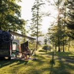 Camper met luifel op een kampeerveld met bomen in Slovenië