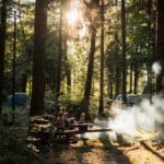 Vuurplaats met vuur en een gezin eromheen in het Sloveense bos