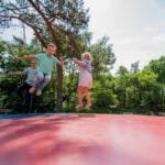 Drie kinderen op een trampoline