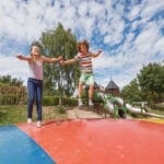 Twee kinderen op een trampoline op een kindvriendelijke camping in Duitsland