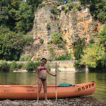 Meisje met een kano op de oever van een rivier in de Dordogne