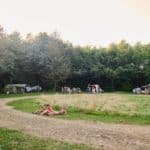 Dire kinderen zitten in het gras op een kampeerveld in het noorden van Nederland