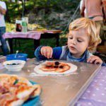 Een kind dat een pizza aan het beleggen is in Italië