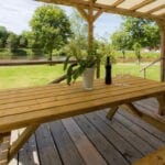 Overdekte veranda met picknicktafel van een Woodlodge in Duitsland
