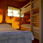 Slaapkamer met drie bedden in een safaritent van Agriturismo Meriggiare