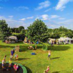 Kinderen spelen op en rond een trampoline op een kindvriendelijke camping in Drenthe