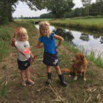 twee kinderen met een hond aan een sloot in Drenthe