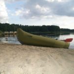 Strand met een roeiboot erop aan een meer