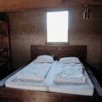 Slaapkamer met tweepersoonsbed in een Juttershut van Duynpark het Zwanenwater