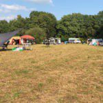Verdord kampeerveld met tenten en campers erop op camping Het Goeie Leven