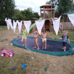 Vier kinderen op een trampoline op familiecamping Oergezellig