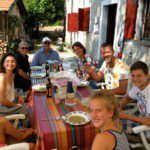 Acht personen aan het eten voor een oud gebouw in de regio Piemonte