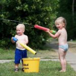 Twee kinderen met water aan het spelen op Farmcamps 't Looveld