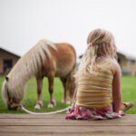 Meisje met een pony op de veranda van een safaritent