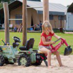 Meisje spelend met een speelgoed traktor bij FarmCamps de Smulhoeve
