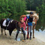 Twee meesjes met pony' s met op de achtergrond een meer in Noord-Brabant