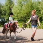 Moeder met een meisje en een pony op een boerderij in Brabant