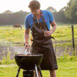 Man aan het barbecuen met op de achtergrond een weiland in Noord-Brabant