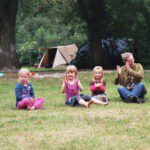 Drie kinderen en een ouder op een kampeerveld op de Veluwe