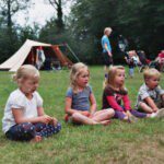 Vier kinderen voor een tent op een kindvriendelijke camping in Gelderland