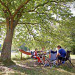 Gezin op stoelen onder een boom in het westen van Frankrijk